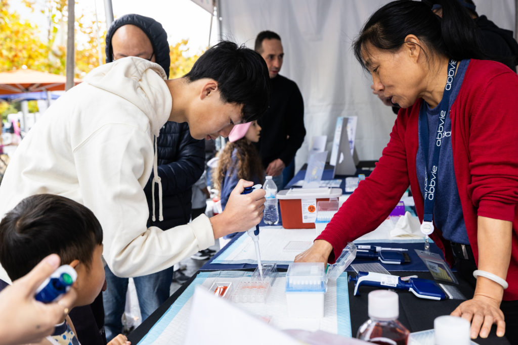 A Festival attendee tries pipetting at Abbvie's booth.