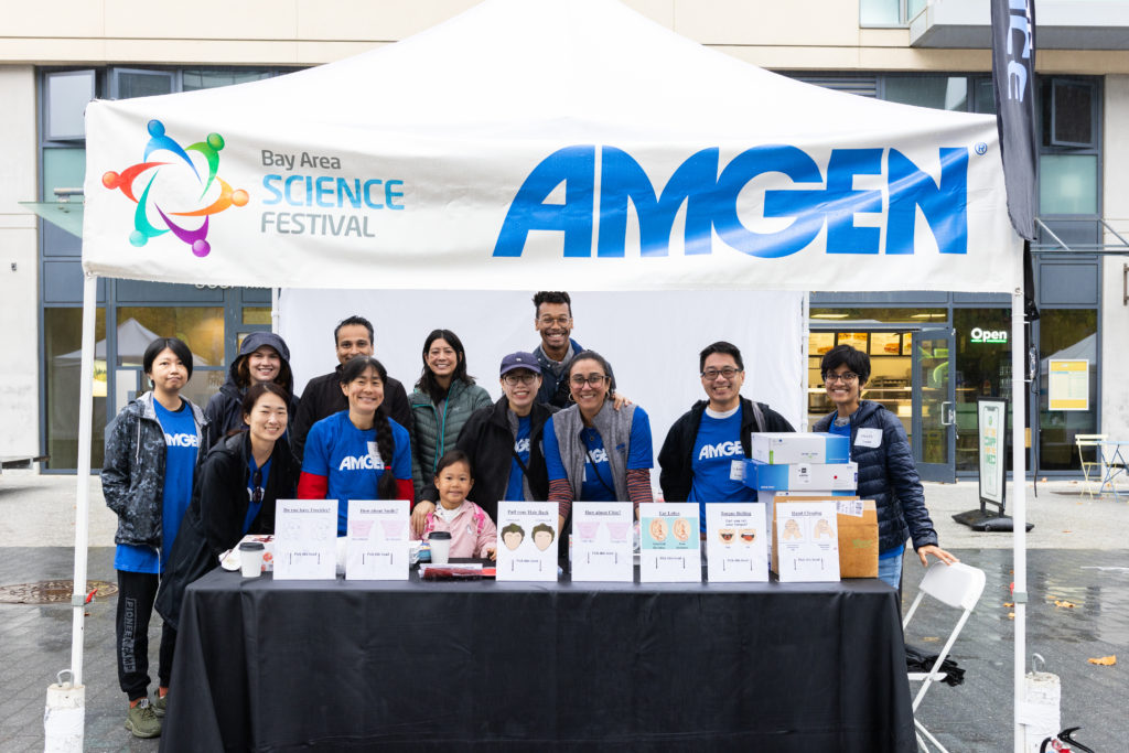 Amgen tent with employees posing for group photo.